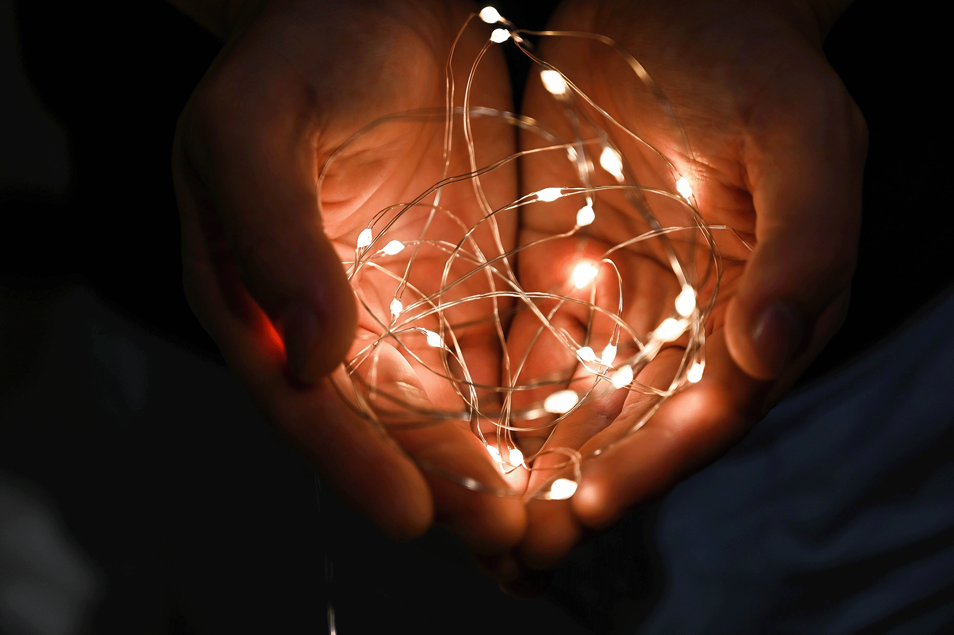 Mini light string lit up in open hands