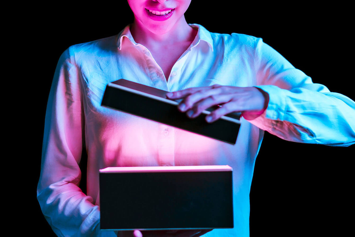 Woman opening a box with gold light mean something exciting inside.