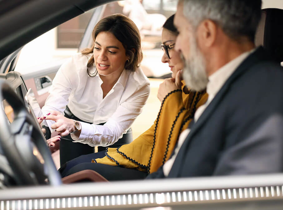 Salesperson demonstrating vehicle features on a tablet