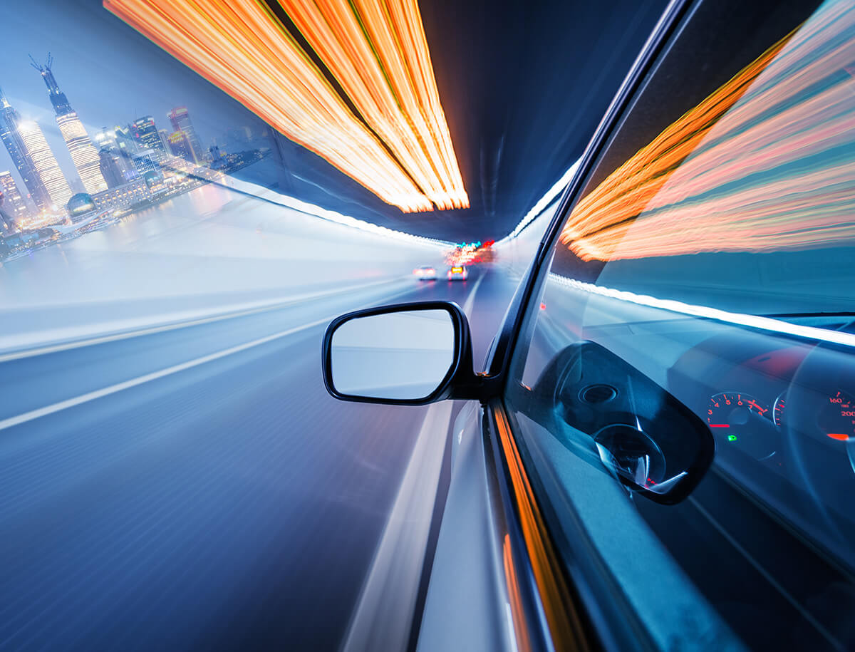 Vehicle mirror POV traveling through nighttime tunnel