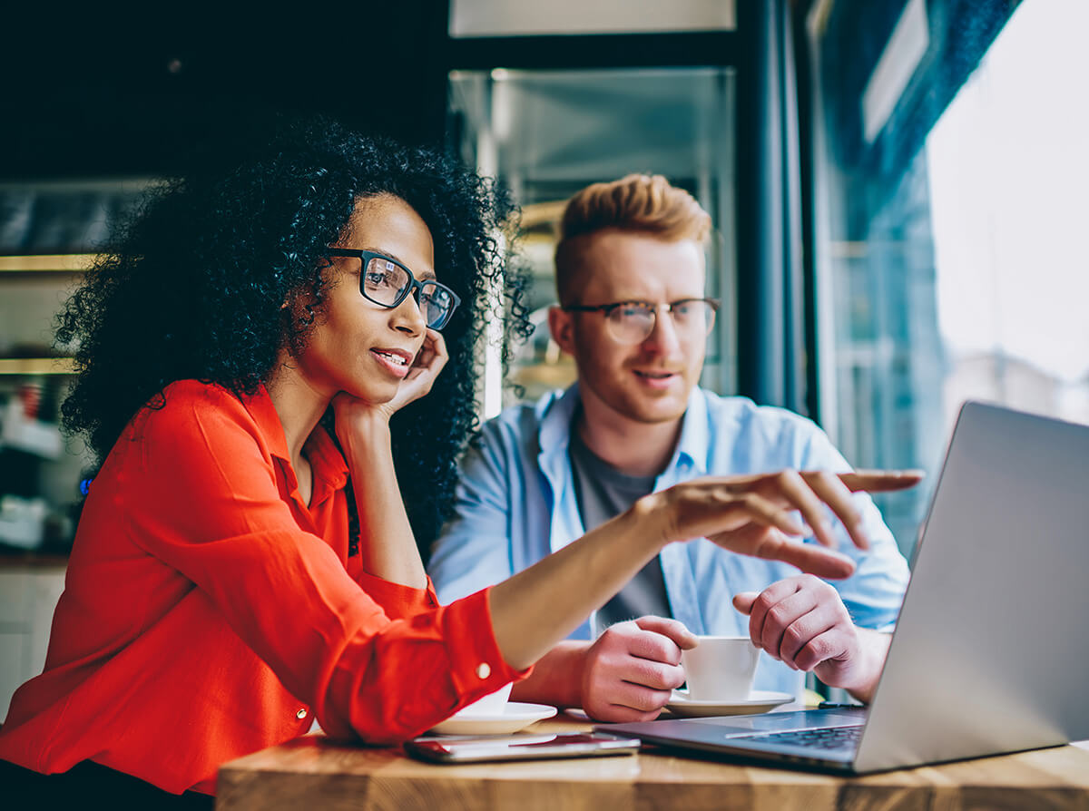 Woman and man consulting a laptop computer