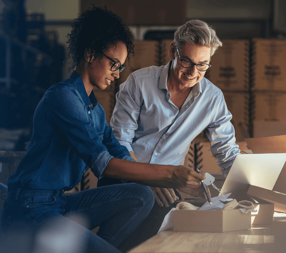 man and woman looking at a box of items to be shipped