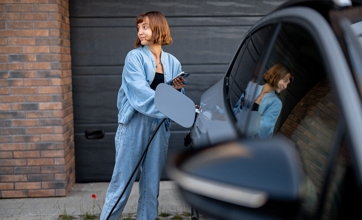 Smiling woman charging an electric vehicle