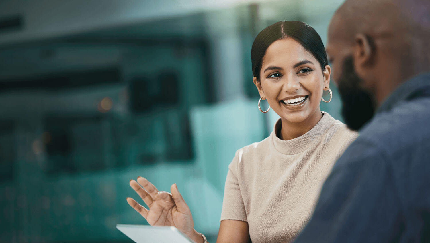 woman and man chatting about a piece of paper at work