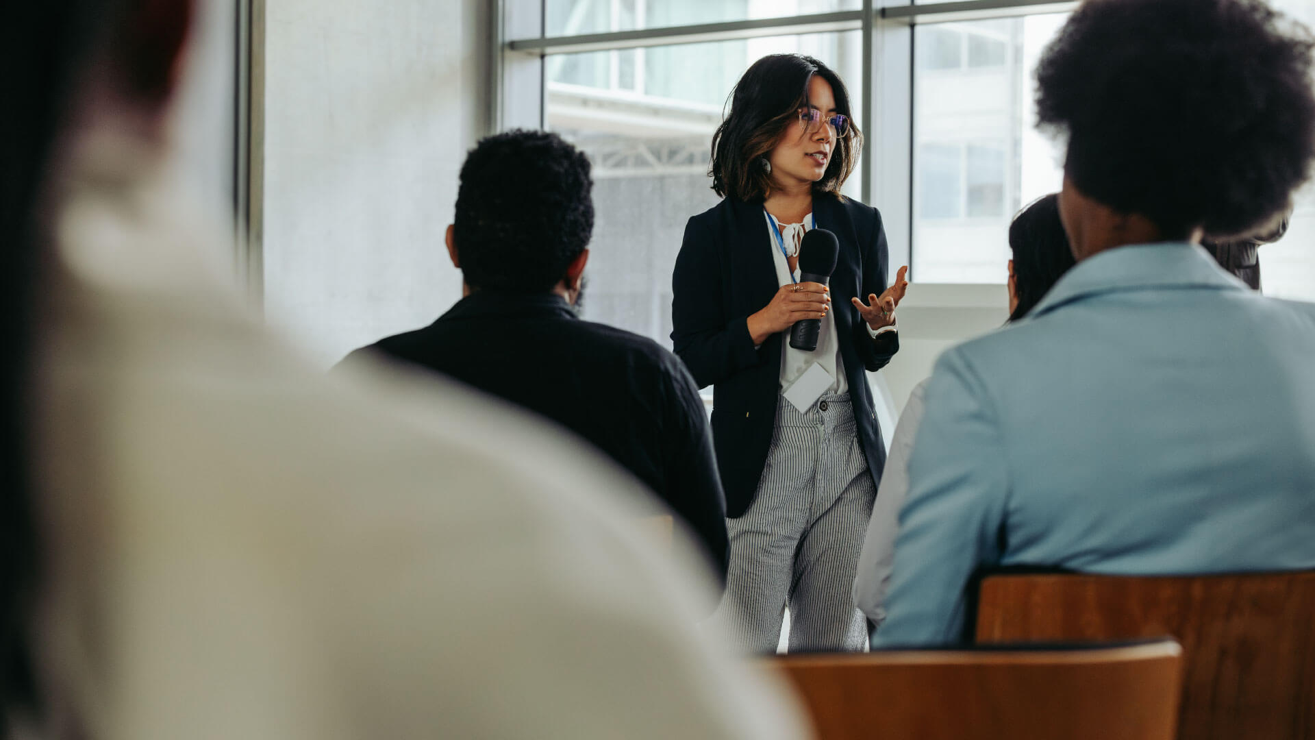 Businesswoman presenting in modern office to coworkers during a meeting