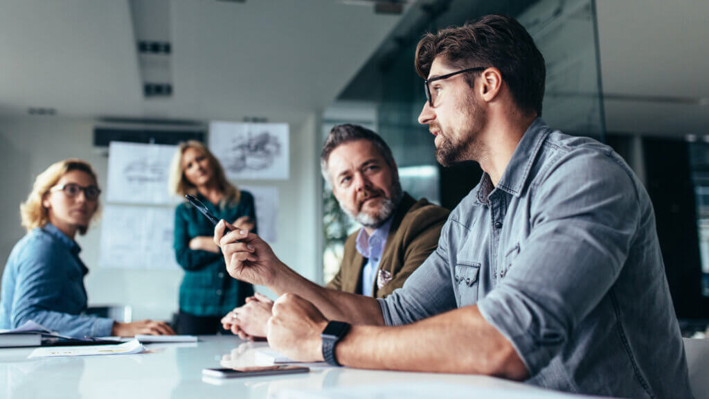 Team collaborating around a conference table during a strategy discussion in a modern office.