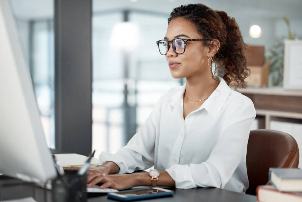 Professional working at a desk using a computer in an office setting